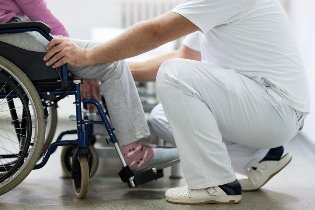 Cuidador a ajudar idosa com mobilidade reduzida